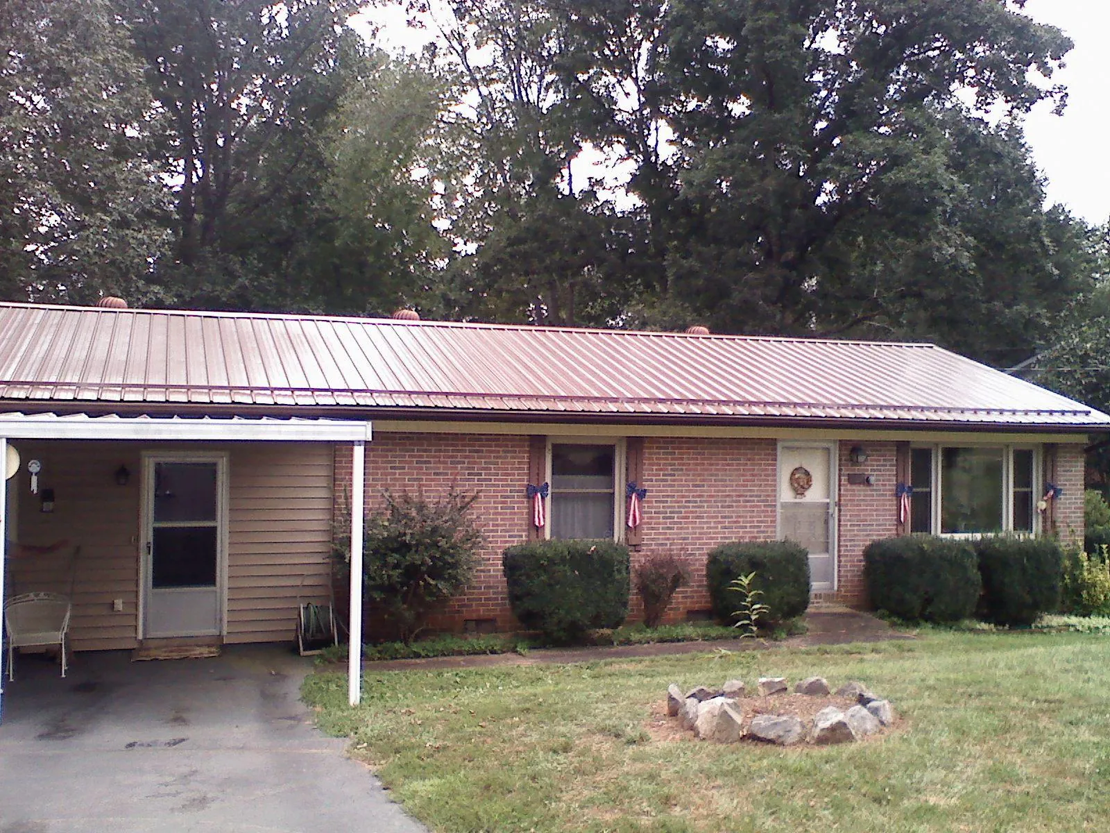 Bronze metal roof and carport on a brick ranch home — Roof Repair work by our crew in Crescent